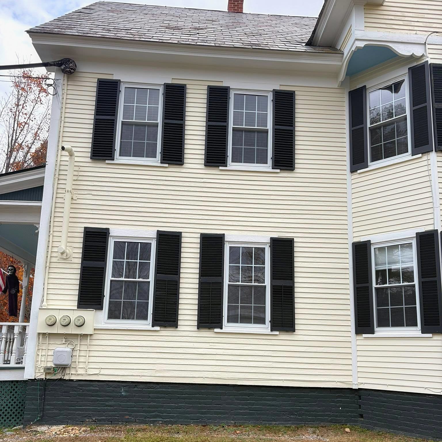After: the same home repainted in clean white with black shutters
